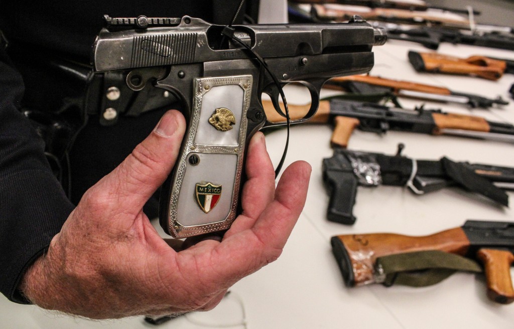 Commander Andrew Smith holds a 9mm handgun. | Daina Beth Solomon
