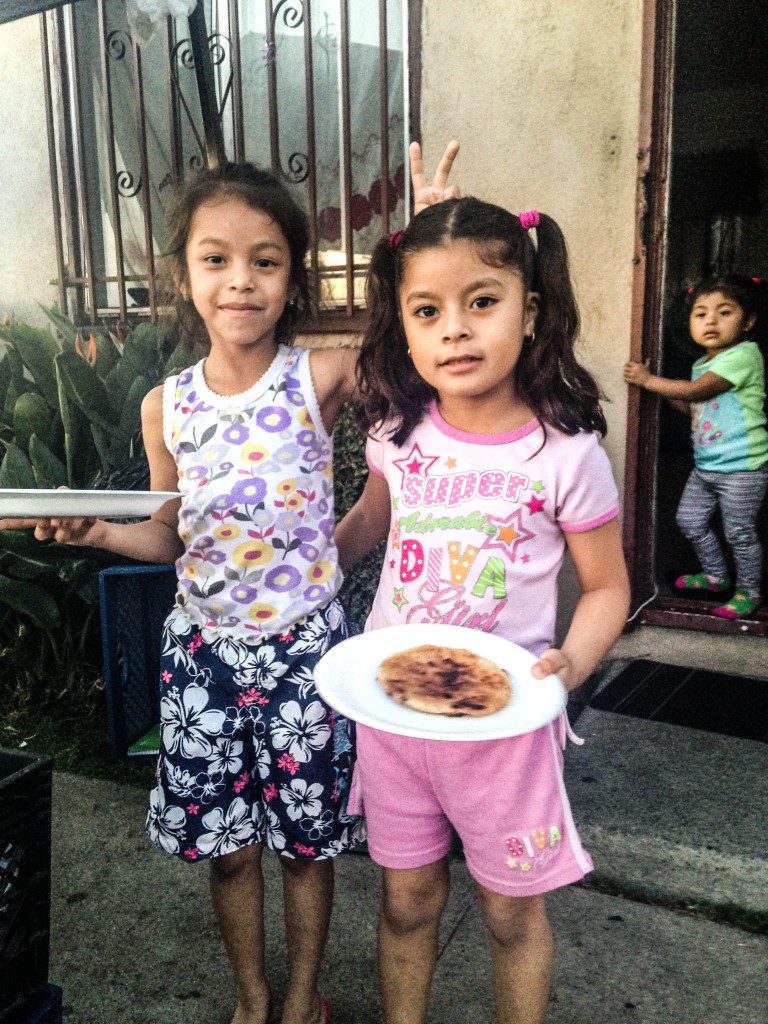 Girls stand outside their house in South LA where their family cooks and sells pupusas at an outdoor stand. | Daina Beth Solomon