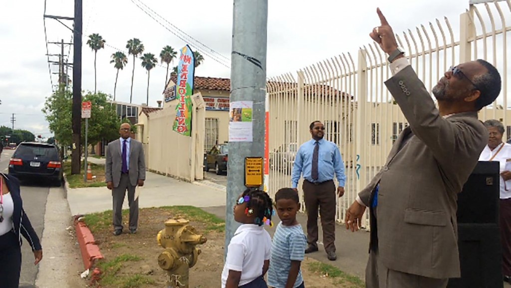 Councilman Curren Price looks up at the new traffic signal on the corner of Figueroa Avenue and 56th Street. 